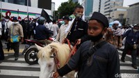 Seorang demonstran tampak membawa kuda.