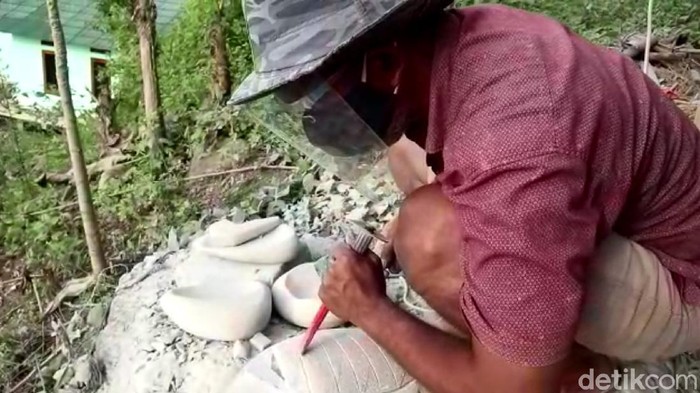 Agus tengah membuat cobek dengan penuh kehatia-hatian.s