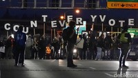 Para pengunjuk rasa memegang Poster untuk menyerukan agar seluruh suara dalam pilpres AS dihitung hingga tuntas mereka melintasi jembatan penyeberangan  di Portland,setelah pemilihan hari Selasa (3/11). (Foto AP / Marcio Jose Sanchez)