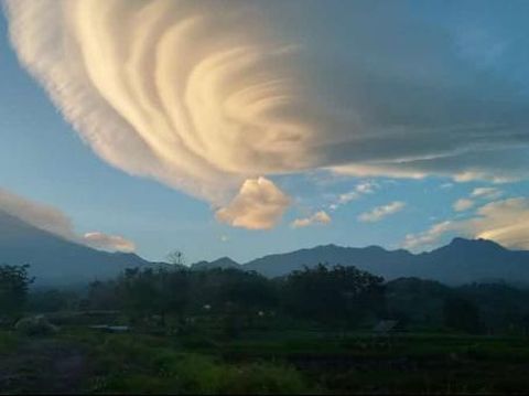 Warga Mojokerto dibuat takjub oleh keindahan awan lentikularis di atas Gunung Welirang dan Anjasmoro, Kecamatan Pacet. Gunung tersebut seperti memakai topi.