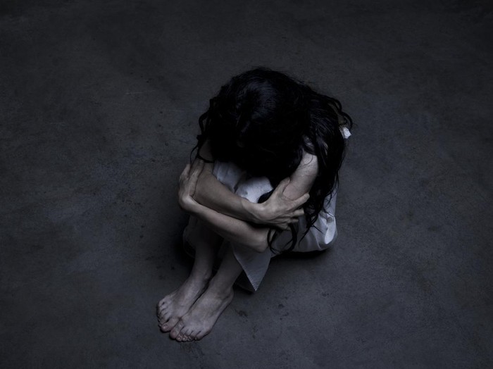 Lonely girl sitting on the floor