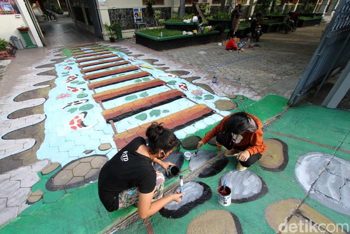 Sejumlah siswa SMP Negeri 24 Solo, Jawa Tengah, mengisi libur sekolah akibat pendemi dengan mengias sekolah lewat teknik mural. Penasaran?