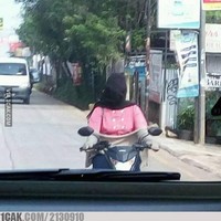 Nasib kalo naik motor nggak pake helm nih. Kerudungnya bisa auto melayang ke belakang. Kalo gini jadi ribet sendiri kan nantinya? Foto: 1cak.com