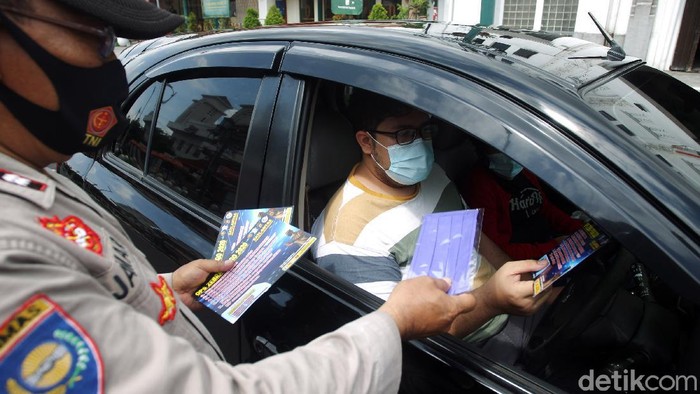 Petugas Kepolisian dari Polresta Kota Yogyakarta membagikan masker, hand sanitizer dan selebaran saat Operasi Zebra Progo 2020 kepada pengendara di Simpang Titik Nol Kilometer, Yogyakarta, Kamis (5/11/2020). Pembagian masker, hand sanitizer dan selebaran bertujuan untuk mencegah persebaran COVID-19 dan kampanye taat protokol kesehatan.