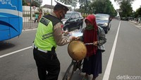 Warga yang mengendarai sepeda pun juga dapat masker dari polisi.
