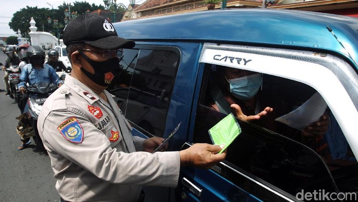 Petugas Kepolisian dari Polresta Kota Yogyakarta membagikan masker, hand sanitizer dan selebaran saat Operasi Zebra Progo 2020 kepada pengendara di Simpang Titik Nol Kilometer, Yogyakarta, Kamis (5/11/2020). Pembagian masker, hand sanitizer dan selebaran bertujuan untuk mencegah persebaran COVID-19 dan kampanye taat protokol kesehatan.