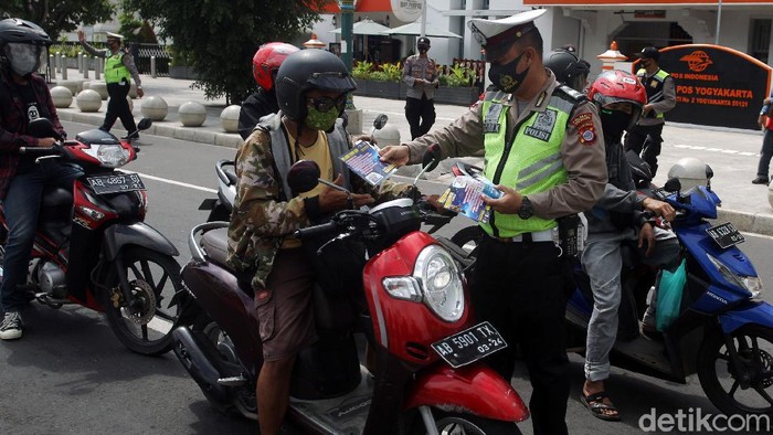 Polisi Bagi-bagi Masker di Yogyakarta Petugas Kepolisian dari Polresta Kota Yogyakarta membagikan masker, hand sanitizer dan selebaran saat Operasi Zebra Progo 2020 kepada pengendara di Simpang Titik Nol Kilometer, Yogyakarta, Kamis (5/11/2020). Pembagian masker, hand sanitizer dan selebaran bertujuan untuk mencegah persebaran COVID-19 dan kampanye taat protokol kesehatan.