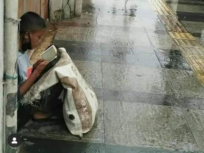Seorang pemulung tengah baca Al-Quran.