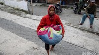Warga tampak membawa barang-barang seperti pakaian dan makanan saat proses evakuasi