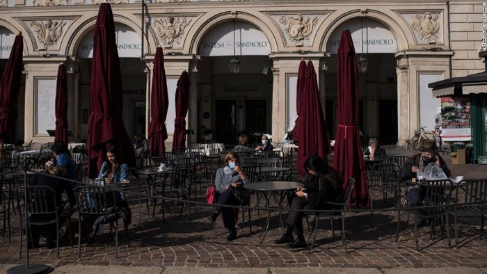 Orang memakai masker di Piazza San Carlo di Turin pada Kamis, sehari sebelum Italia memasuki lockdown.
