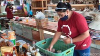 Seorang pedagang yang merapikan dagangannya.