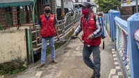 Pundak mereka menggendong mesin pompa kotak yang berisi cairan desinfektan. Sesekali tuas yang ada dibagian kanan mesin terus diayun naik turun agar cairan yang keluar menjadi embun.  