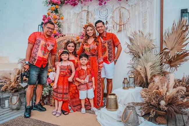 Perayaan ulang tahun istri Anang Hermansyah ini digelar meriah. Dia dan keluarganya pun kompak mengenakan busana oranye kemerahan bermotif tenun. Foto: Instagram/@ashanty_ash, @aurelie.hermansyah