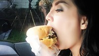 Makan burger yang ukurannya cukup besar, Tessa sempat kesulitan untuk menghabiskan salah satu makanan kesukaannya ini. Foto: Instagram @tessakaunang_tuiit