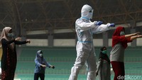 Petugas medis dengan menggunakan seragam APD, memimpin senam  bersama para pasien COVID-19.