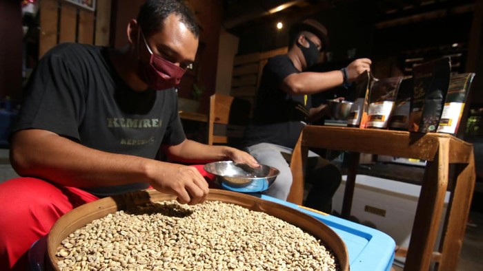 Pekerja melakukan proses foto produk kopi untuk dipasarkan secara daring di Kemiren, Banyuwangi, Jawa Timur, Jumat (6/11/2020). Pemilik Usaha Mikro, Kecil dan Menengah (UMKM) itu mengaku saat ini usaha pembuatan produk kopi mulai bangkit karena meningkatnya kunjungan wisatawan ke pusat oleh-oleh serta pemasaran produk yang dilakukan secara daring. ANTARA FOTO/Budi Candra Setya/wsj.