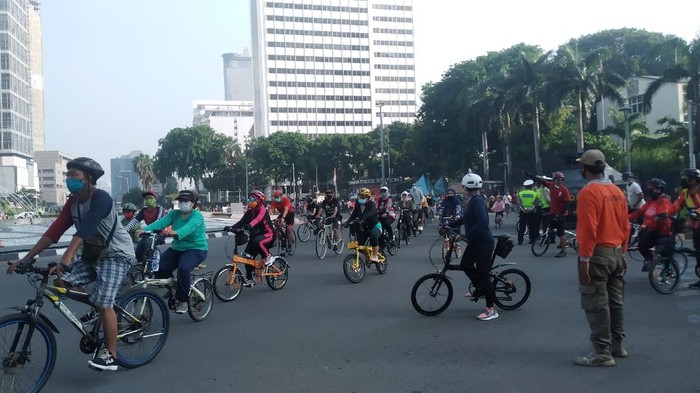 Warga Jakarta berolahraga di kawasan Bundaran HI saat PSBB transisi. Warga bersepeda mendominasi, Minggu (8/11/2020).