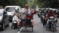 Warga menggunakan topeng berwajah pasangan Presiden Amerika Serikat terpilih Joe Biden (kiri) dan Wakil Presiden Kamala Harris (kanan) di Jalan Slamet Riyadi, Solo, Jawa Tengah, Minggu (8/11/2020).