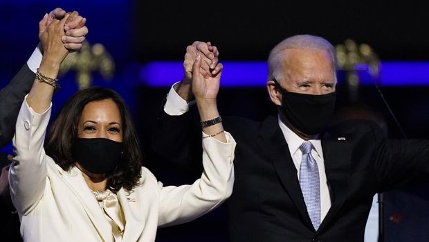 Vice President-elect Kamala Harris holds hands with President-elect Joe Biden and her husband Doug Emhoff as they celebrate Saturday, Nov. 7, 2020, in Wilmington, Del. (AP Photo/Andrew Harnik)