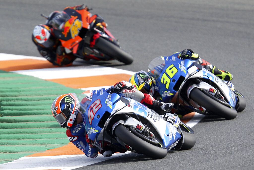 Spain's rider Alex Rins of the Team SUZUKI ECSTAR leads on Spain's rider Joan Mir of the Team SUZUKI ECSTARand Spain's rider Pol Espargaro of the Red Bull KTM Factory Racing in the MotoGP race during the European Grand Prix in Valencia, Spain, Sunday, Nov. 8, 2020. (AP Photo/Alberto Saiz)