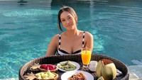 Pose seksi Anya Geraldine juga tampak pada momen floating breakfast ini. Sambil berenang, Anya bisa santai makan salad, buah hingga jus jeruk. Foto: Instagram @Anyageraldine