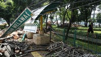 Batang pohon yang telah dipotong-potong masih dikumpulkan di sekitar halte.