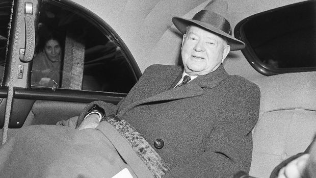 Mantan Presiden AS Herbert Hoover Former President Herbert Hoover appears happy as he sits in car at Idlewild Airport in the Queens borough of New York, Nov. 27, 1954, after arrival from a six-day trip to Germany where he received an honorary doctorate in political science from Tubingen University. Hoover made the trip at the invitation of of West German Chancellor Adenauer. (AP Photo)