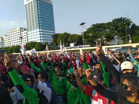Massa buruh yang demo menolak UU Ciptaker di depan gedung DPR/MPR membubarkan diri. Mereka sempat mengacungkan jari tengah yang dianggap mereka sebagai simbol perlawanan (Sachril Agustin/detikcom)