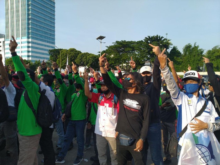 Massa buruh yang demo menolak UU Ciptaker di depan gedung DPR/MPR membubarkan diri. Mereka sempat mengacungkan jari tengah yang dianggap mereka sebagai simbol perlawanan (Sachril Agustin/detikcom)