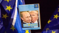 Sebuah poster yang menunjukkan Donald Trump berciuman dengan Vladimir Putin dipasang di Reli Uni Eropa di Edinburgh, Skotlandia. Getty Images/Robert Perry  