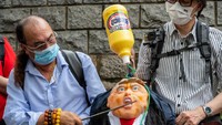 Saat pendukung Pro-China memegang patung Trump di luar Konsulat AS di Hong Kong, China. Getty Images/Billy H.C. Kwok  