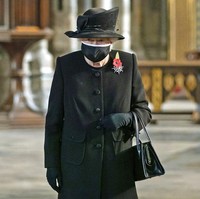 Begitu pula masker Ratu yang matching dengan pakaian dan aksesorinya. Tidak ketinggalan bros berbentuk bunga popi sebagai bentuk penghormatan bagi pahlawan Inggris. (Foto: AP/Aaron Chown)
