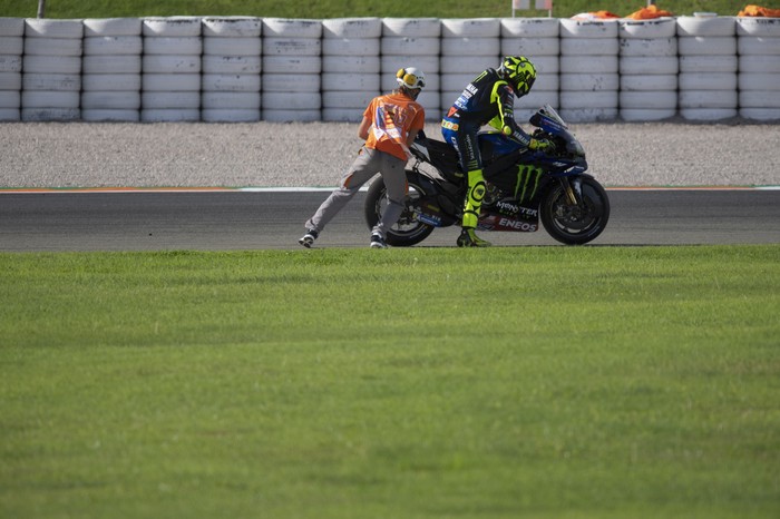 VALENCIA, SPAIN - NOVEMBER 08: Valentino Rossi of Italy and Monster Energy Yamaha MotoGP Team push the bike with marshall staff  during the MotoGP race during the MotoGP of Europe at Comunitat Valenciana Ricardo Tormo Circuit on November 08, 2020 in Valencia, Spain. (Photo by Mirco Lazzari gp/Getty Images)