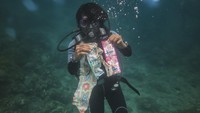 Seorang penyelam mengumpulkan sampah plastik yang ditemukan di perairan Pulau Haruku, Maluku.