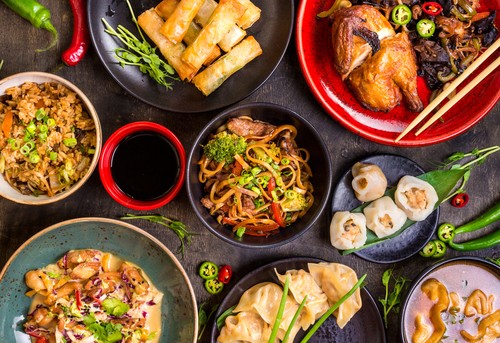 Assorted Chinese food set. Chinese noodles, fried rice, dumplings, peking duck, dim sum, spring rolls. Famous Chinese cuisine dishes on table. Top view. Chinese restaurant concept. Asian style banquet