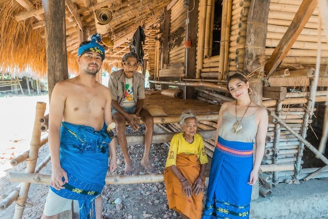 Nagita dan Raffi Ahmad kompak tampil dengan kain tenun Sumba berwarna biru. Jika suaminya hanya memakai kain Sumba saja, Nagita melengkapi penampilannya dengan tank top yang warnanya senada dengan warna kulitnya. Penampilannya ini lah yang membuat netizen salah fokus. Bukannya mengomentari gaya Nagita berbaju adat Sumba, netizen malah mengomentari kulit putih nan bersih Nagita.  Foto: Instagram