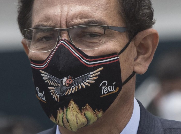 Wearing a mask amid the COVID-19 pandemic, Peruvian President Martin Vizcarra talks to reporters before entering Congress in Lima, Peru, Monday, Nov. 9, 2020. Peru’s president faces a second impeachment vote in less than two months Monday over new accusations of corruption in the latest jolt to one of the countries hardest hit by the coronavirus pandemic. (AP Photo/Rodrigo Abd)