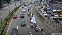 Tampak mereka mengibarkan bendera sambil berkendara.