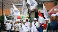 Mereka membawa bendera tauhid, bendera merah putih, serta pernak-pernik bergambar Habib Rizieq.