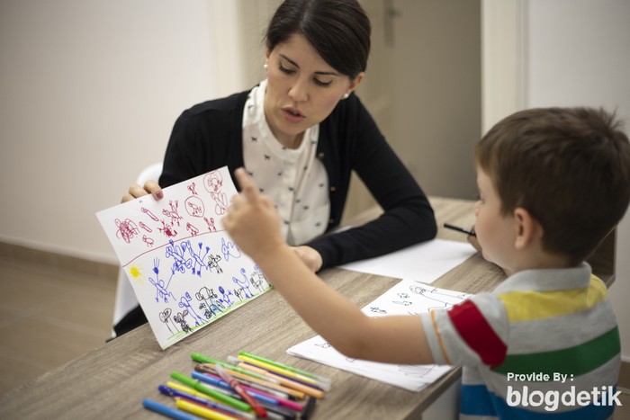 Five years old boy drawing at the psychotherapy session.