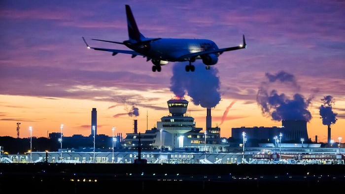 The last Lufthansa flight of the Airbus A350 aircraft from Tegel Airport is taxiing to the take-off field as it is bid farewell by the airport fire brigade with a fountain of water in Berlin, Germany, Saturday, Nov. 7, 2020. The final flight is scheduled for Sunday. (Fabian Sommer/dpa via AP)