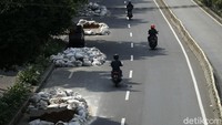 Sejumlah pegendara sepeda motor melintas di depan proyek galian.