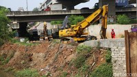 Para pekerja melakukan pelebaran jembatan Kali Cakung sisi selatan. 