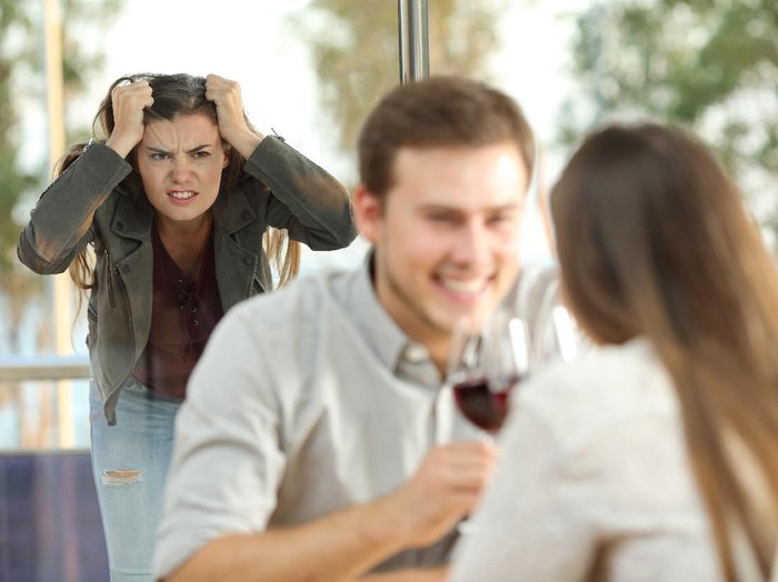 Disloyal boyfriend caught by his angry girlfriend dating with another girl in a restaurant