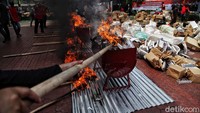 Barang bukti dibakar di dalam sejumlah tong.