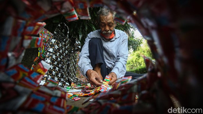 Santo (78) menganyam bungkus plastik bekas untuk dibuat barang berharga di kawasan Kebayoran Baru, Jakarta, Rabu (11/10/2020).