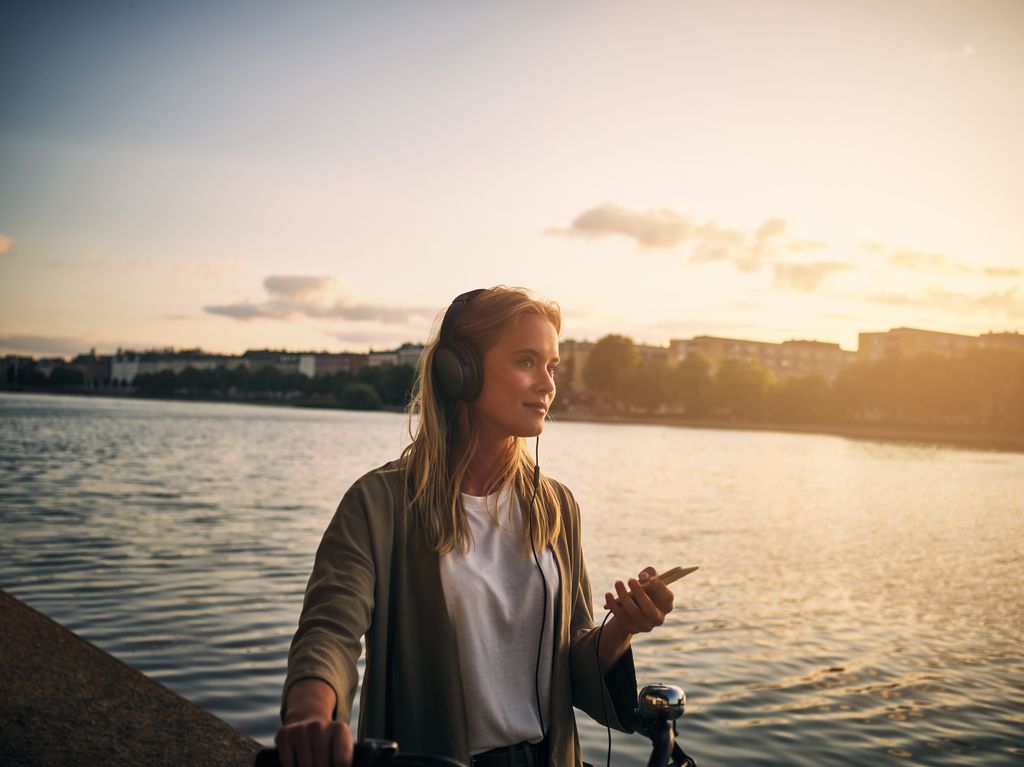 917742572 Cropped shot of a beautiful young woman listening to music with her cellphone outside