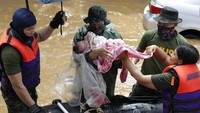 Petugas mengevakuasi seorang bayi di kawasan Marikina, Filipina, yang direndam banjir imbas Topan Vamco yang melanda kawasan tersebut, Kamis (12/11/2020). AP Photo/Aaron Favila.