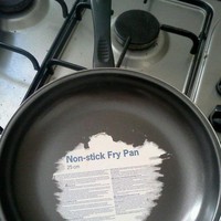 Makanannya sih nggak lengket, tapi malah stikernya yang lengket di teflon. Kalau begini harus diapain nih? Foto: Reddit