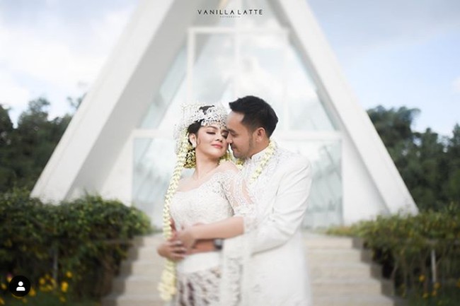 Jenita Janet tampil dalam balutan kebaya pengantin putih karya Berkat Kebaya. Sang desainer menulis di Instagramnya, kebaya pengantin Jenita tersebut dibuat mewah dengan taburan mutiara dan kristal Swarovski. Foto: Instagram @vanillalatte.photo